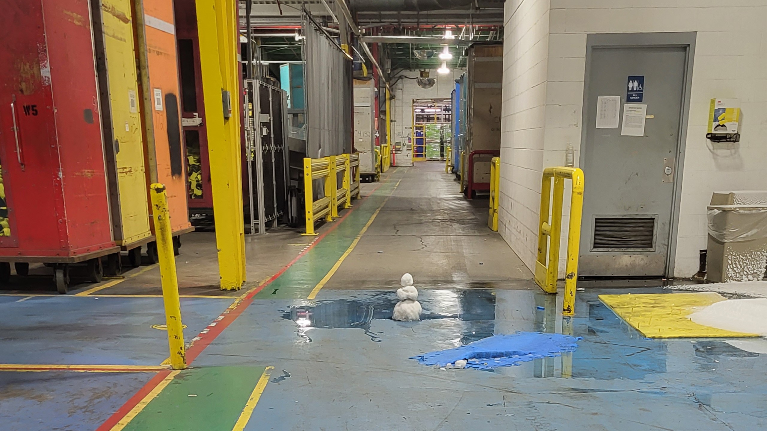 A small snowman in the hallway of a plant loading room.